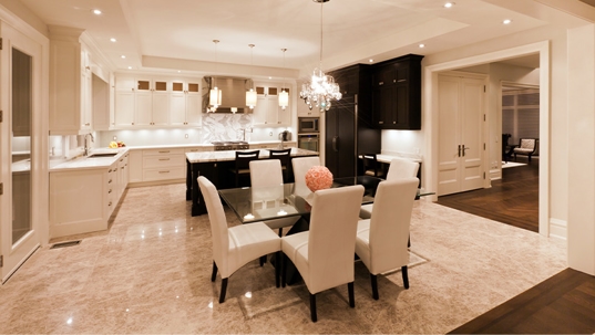 Kitchen and dining room lit up at night with hanging lights